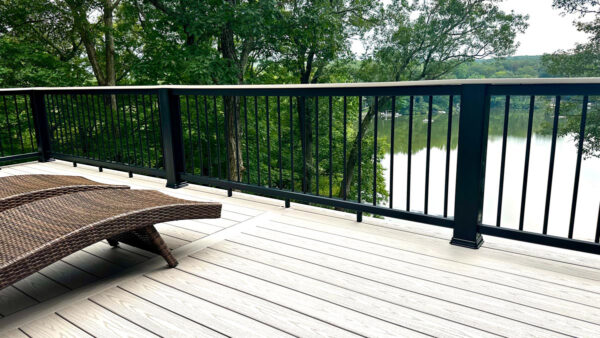 Image of a 2-story deck in Bloomingdale, Passaic County, NJ, featuring Timbertech PVC Decking, Composite Rail with Drink Top, and Round Metal Balusters.