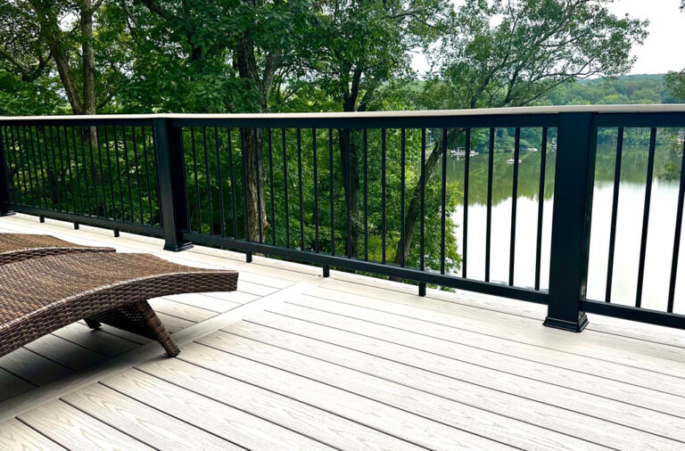 Image of a 2-story deck in Bloomingdale, Passaic County, NJ, featuring Timbertech PVC Decking, Composite Rail with Drink Top, and Round Metal Balusters.