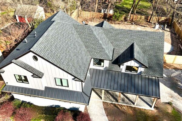 aerial-view-of-dark-gray-roof-and-house-with-white-siding-and-wooden-fence-in-back-yard
