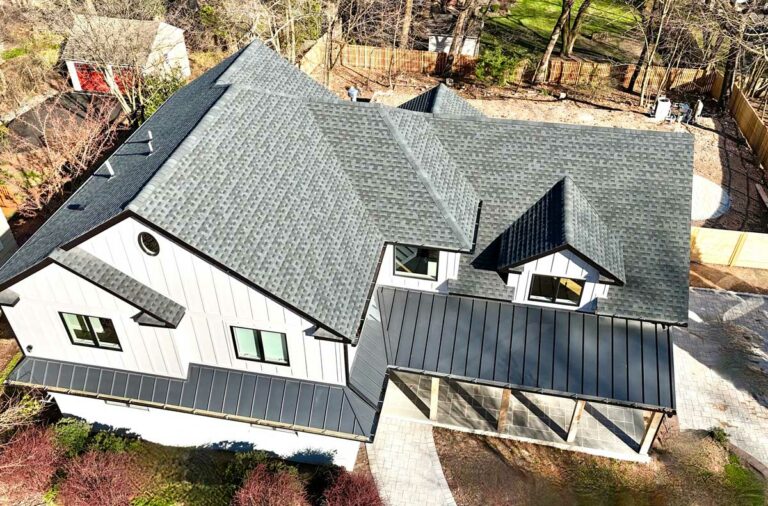 aerial-view-of-dark-gray-roof-and-house-with-white-siding-and-wooden-fence-in-back-yard