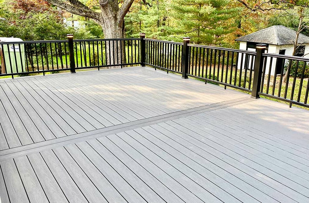 A deck located in Summit, NJ with Azek boards of a medium brownish-grey and black railing overlooking a backyard in New Jersey.