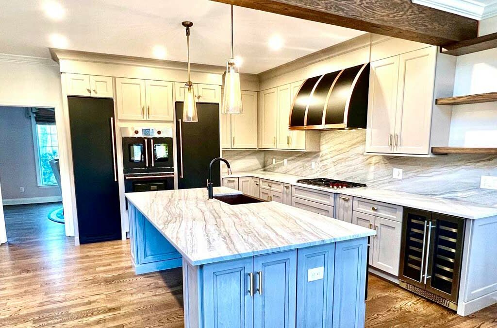 An open-concept kitchen in Watchung, NJ with new hardwood flooring, open ceiling beam, and new cabinetry with marble countertops.