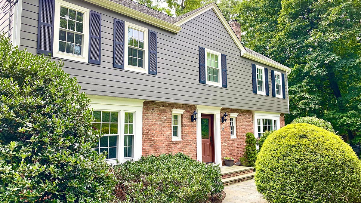 blue-and-brick-house-with-shrubs-and-front-door