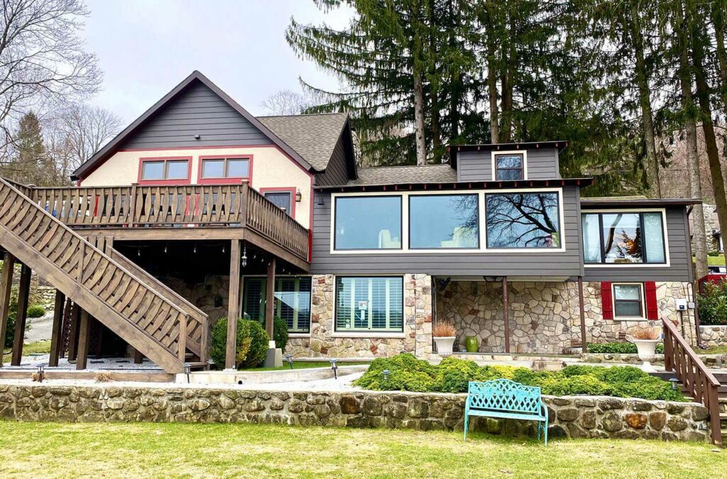 back-of-lodge-house-with-stone-and-brown-stairs-leading-from-deck