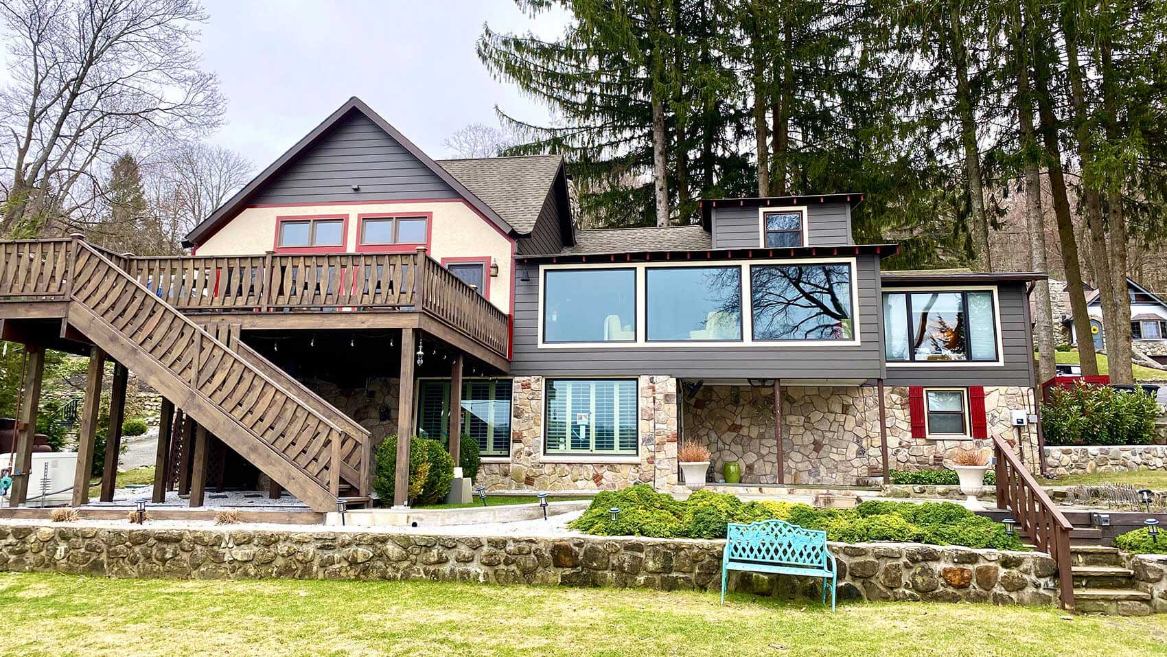 back-of-lodge-house-with-stone-and-brown-stairs-leading-from-deck