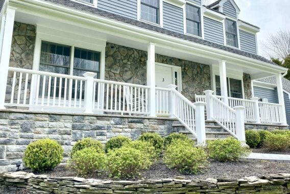 blue-house-with-white-porch-and-stone-steps